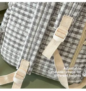 Close-up of adjustable strap and lace trim on the grey plaid stylish backpack