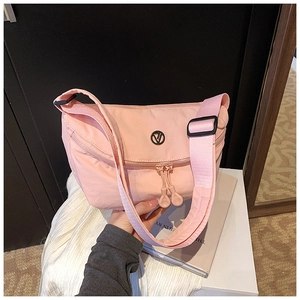 Detail of light pink nylon crescent bag with adjustable wide strap and round logo