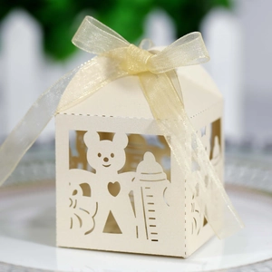 Detail of laser-cut baby shower candy box with teddy bear pattern and organza ribbon