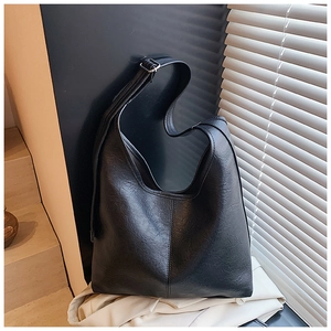 Detailed view of the black lychee-textured leather bucket bag with silver buckle