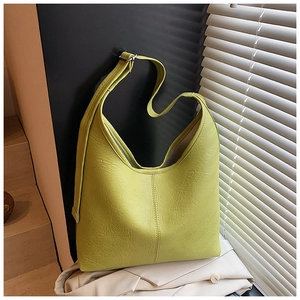 Detail of lime green wrinkled leather texture and adjustable strap on large tote bag