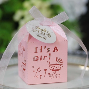 Détail de la boîte cadeau rose 'It's A Girl' avec découpe laser cœur et ruban blanc
