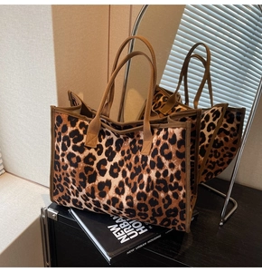 Detailed close-up of large leopard print tote bag on display with elegant interior decor