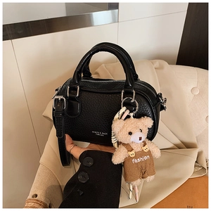 Detail of black pebbled leather mini Boston bag with silver hardware and bear charm