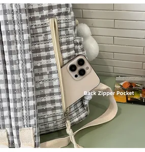 Detail of the back anti-theft zipper pocket on gray plaid backpack with lace trim