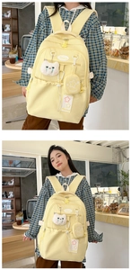 Detail of light yellow waterproof backpack featuring cute cat pendant and star coin purse