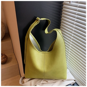 Detail of light green bucket bag showing soft pleated PU texture and adjustable buckle