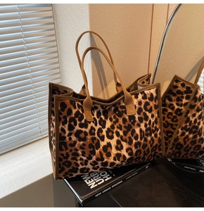 Detailed view of leopard print tote bag placed on a book in a modern home setting