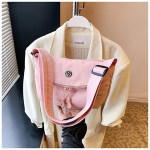 Detail of pink nylon crossbody bag with multi-layer zippers and metallic logo