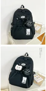 Détail du sac à dos en nylon noir avec motif étoile et mini porte-monnaie suspendu