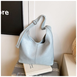 Close-up of a blue crescent hobo bag with adjustable metallic buckle and leather texture