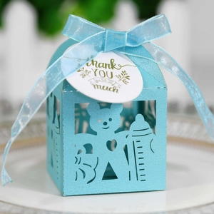 Détail d'une boîte à bonbons bleu clair découpée au laser avec motif ours et ruban