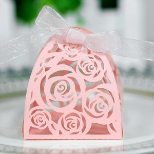 Detail of pink laser-cut rose candy box with a silver satin ribbon for weddings