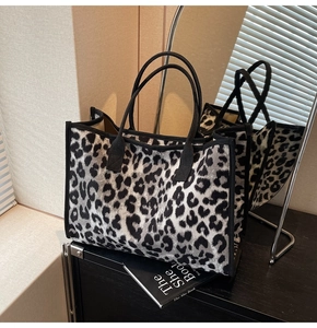 Detailed view of leopard print tote bag against a mirror in a modern interior setting