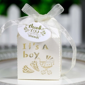 Detail of laser-cut baby carriage candy box with ribbon and Thank You tag for boy's baptism