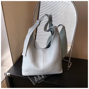Detail of light blue-grey pleated leather tote bag with wide adjustable shoulder strap