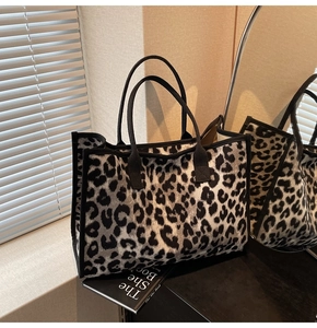 Macro detail of high-capacity leopard print tote bag with reinforced black strap