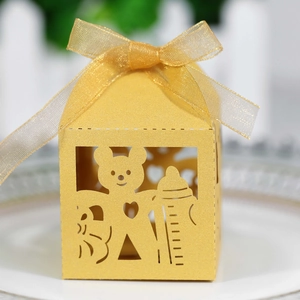 Macro view of golden laser-cut gift box with bear and baby bottle hollow design