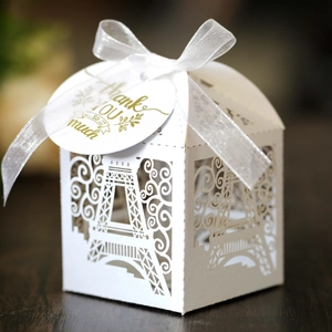 Detailed laser-cut Eiffel Tower favor box with white ribbon and Thank You gold tag