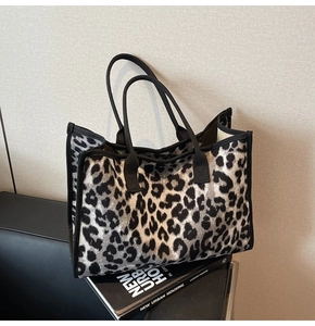 Detail of trendy leopard print tote bag with black fabric handles and spacious design