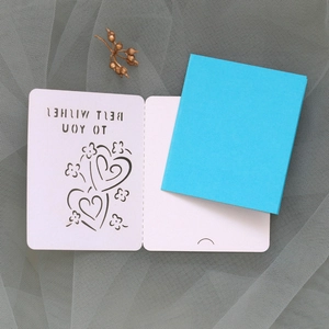 Detail of laser-cut 'Best Wishes' card with heart pattern and sky blue envelope