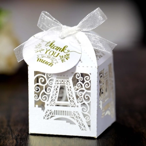 Detailed laser-cut Eiffel Tower favor box with white ribbon and Thank You tag on wood
