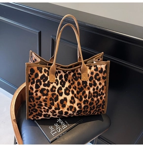 Detail of leopard print tote bag showing canvas texture and dark brown reinforced handles