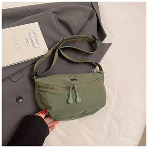 Detail of army green nylon half-moon crossbody bag with dual zipper closure and web strap