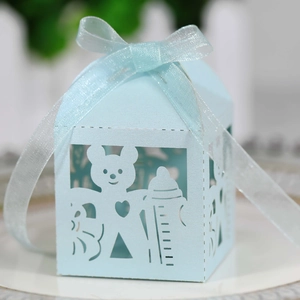 Macro detail of laser-cut light blue baby favor box with cute bear and ribbon bow
