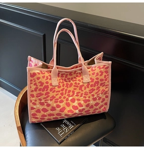 Detail of pink leopard print canvas tote bag featuring durable handles and fabric texture