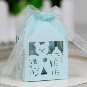Detail of light blue laser-cut candy box featuring hollow bear and bottle patterns