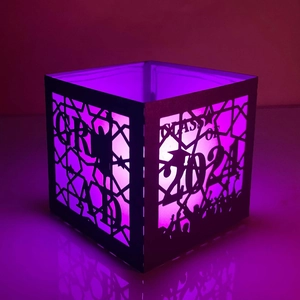 Macro shot of 2024 graduation paper lantern with purple light and hollow grad silhouette