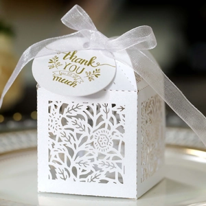 Macro detail of laser-cut rose gift box with white ribbon and thank you tag