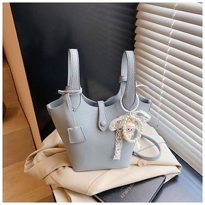 Detail of light blue lychee pattern leather bucket bag with pearl rabbit charm