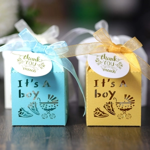 Detail of laser-cut baby carriage candy box with 'It's a Boy' text and silk ribbon