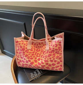 Detailed view of pink leopard print canvas tote bag on a premium black leather seat