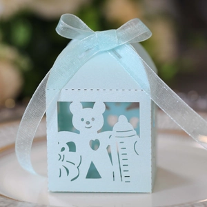 Close-up of light blue laser-cut baby shower gift box with bear and ribbon detail