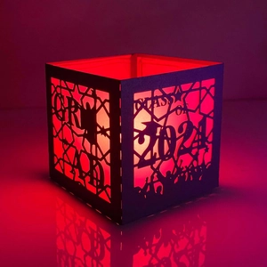Detail of laser-cut 'CLASS OF 2024' paper lantern with red glowing LED light