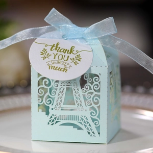 Detail of light blue laser-cut Eiffel Tower favor box with thank you tag and ribbon