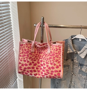Detailed close-up of a pink leopard print canvas tote bag with reinforced handles