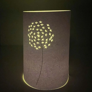 Detail showing laser-cut dandelion pattern on frosted cylindrical decorative LED lamp