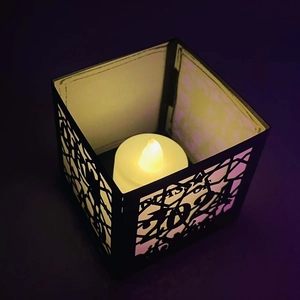 Macro view of Class of 2024 laser cut black luminary with warm LED candle light inside