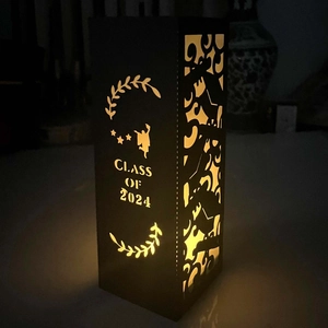 Detail view of Class of 2024 paper lantern with laser-cut graduation silhouettes and warm light