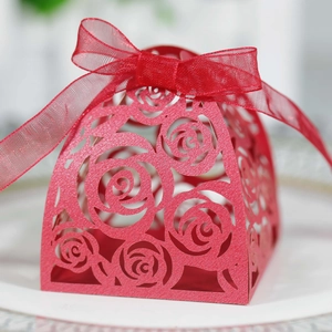 Macro detail of red laser-cut rose gift box with shimmering paper and organza ribbon