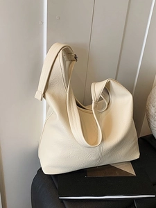 Chic beige bucket bag with textured faux leather and adjustable silver buckle