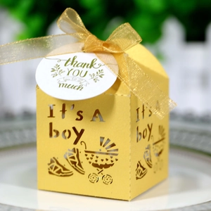 Detail of yellow laser-cut 'It's A Boy' favor box with ribbon and thank you tag