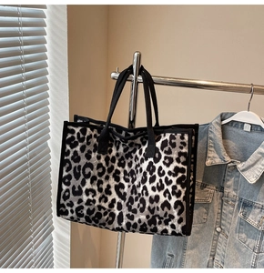 Close-up of leopard print tote bag hanging on a rack with natural sunlight and soft shadows