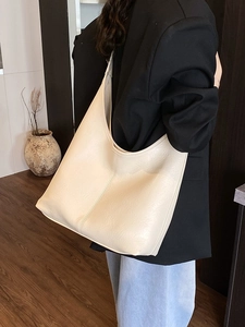Minimalist beige Hobo bucket bag for women featuring a spacious and textured faux leather design