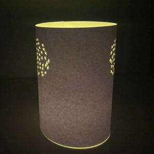 Detailed view of laser-cut geometric patterns on a grey cylindrical LED candle shade