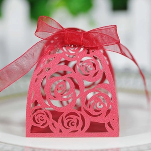 Detail of laser-cut red rose candy box with an elegant matching silk ribbon bow